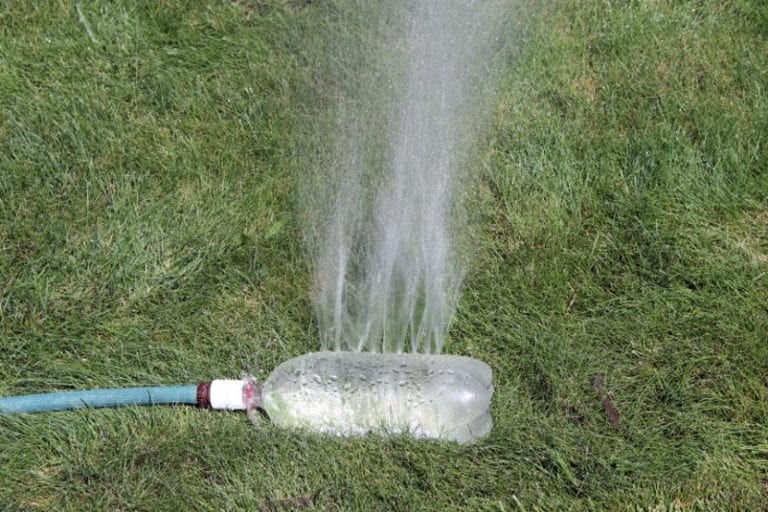 Aspersor casero hecho con una botella de plástico regando el jardín