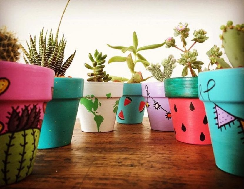 Macetas decoradas con pintura de colores en una terraza