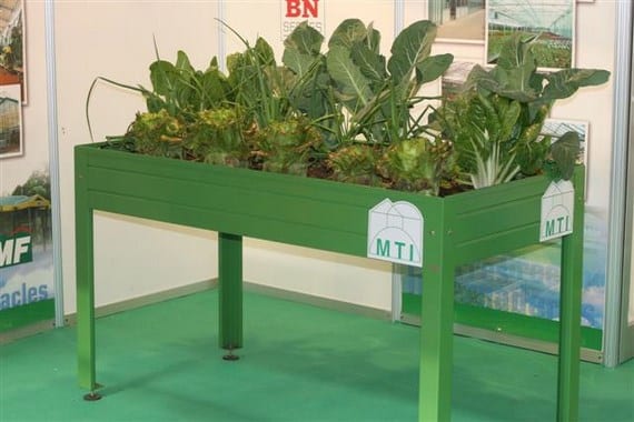 Mesa de cultivo de madera con hortalizas en una terraza
