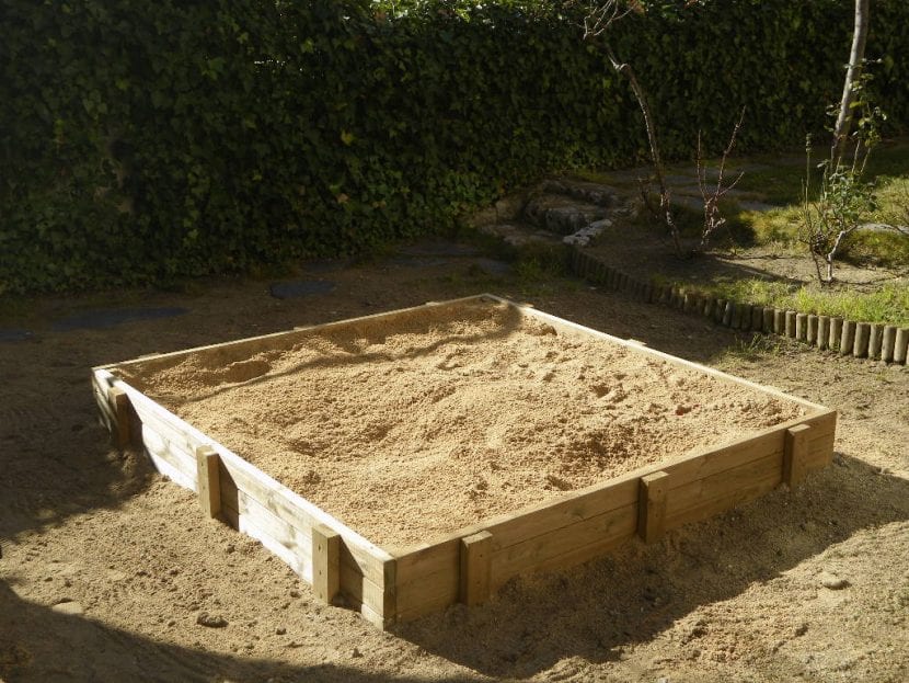 Arenero infantil de madera en el jardín