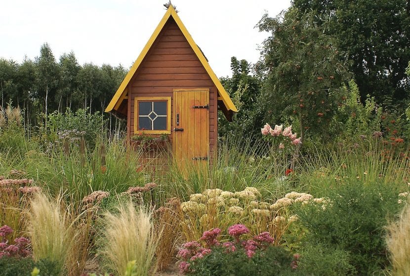 Jardín rural con masas de vegetación y camino de tierra