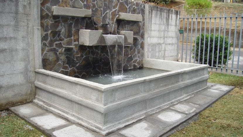 Fuente de pared con pileta en un patio