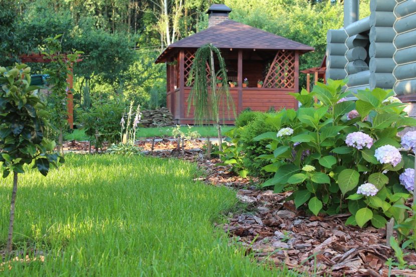 Jardín con vegetación densa y zona de estar resguardada